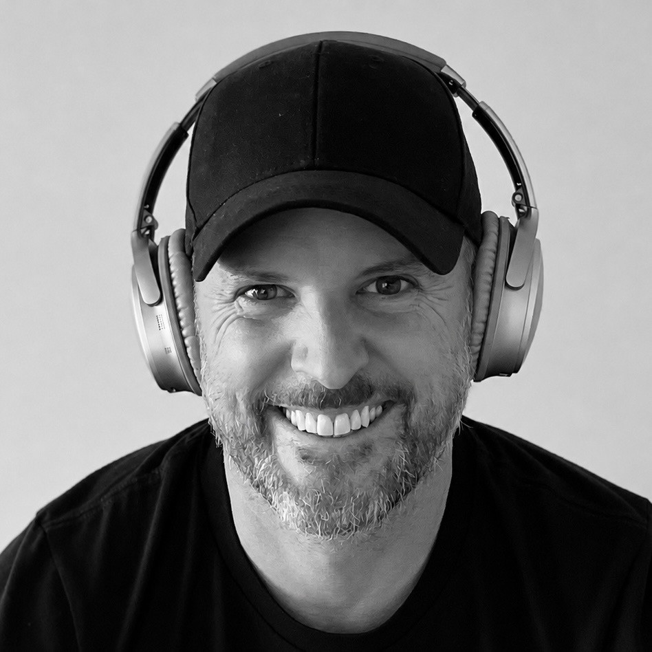 Rich Taylor smiling, wearing a black cap and headphones